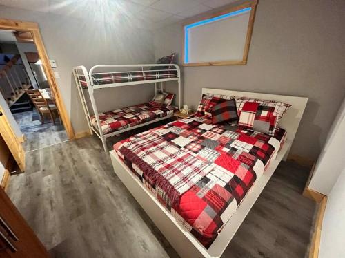 sypialnia z 2 łóżkami piętrowymi w pokoju w obiekcie Hébergement paisible à la montagne w mieście LʼAnse-Saint-Jean