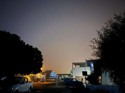 a parking lot with cars parked in front of a building at DE VISSCHUUR in Paternoster