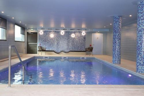 ポワシーにあるDOMITYS Résidence services seniors LE PARC DES AUBIERSのプールのある建物内のプール