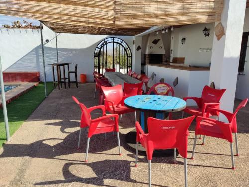 a group of red chairs and a blue table and chairs at La Isla de la Vía in Archidona