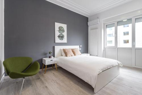ein Schlafzimmer mit einem Bett und einem grünen Stuhl in der Unterkunft Modern Apartment in the Heart of Bucharest in Bukarest