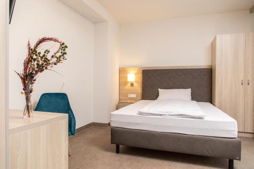 a bedroom with a bed and a blue chair at Gesundheits- & Wellnessresort Salzerbad in Kleinzell