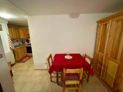 a dining room with a red table and chairs at BOUQUE GEORGEOLINE in Rhêmes-Notre-Dame