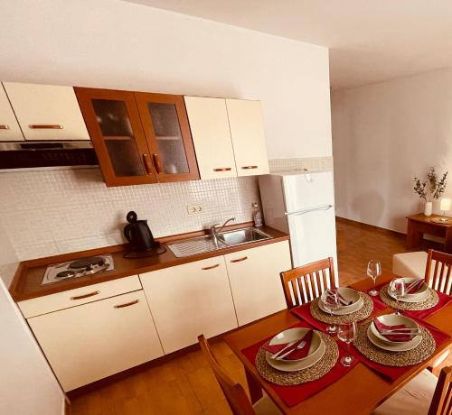 uma cozinha com uma mesa com pratos em Apartments Stina em Seget Vranjica