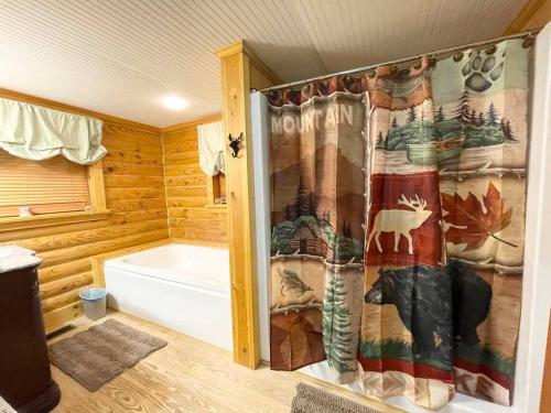 y baño con bañera y cortina de ducha. en One of a Kind Rustic Log Cabin near Bryce Resort - Large Game Room - Fire Pit - Large Deck - BBQ, en Basye