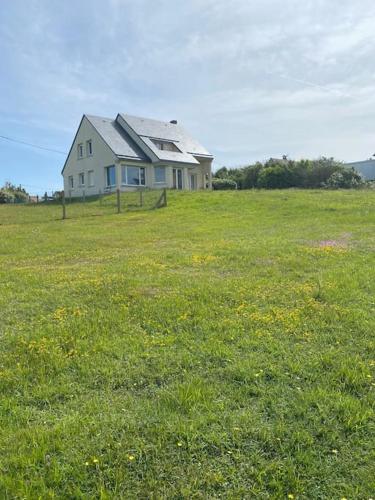 a house in the middle of a field of grass at Grande maison chaleureuse avec vue mer imprenable in Criel-sur-Mer