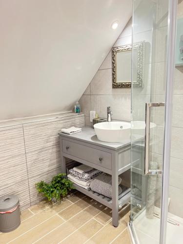 een badkamer met een wastafel en een glazen douche bij Entire Loft Space in quiet village near Roman City of Lincoln in Lincoln