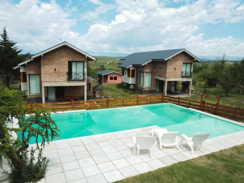 a house with a swimming pool in the yard at Pentagrama, casas de campo in Villa General Belgrano