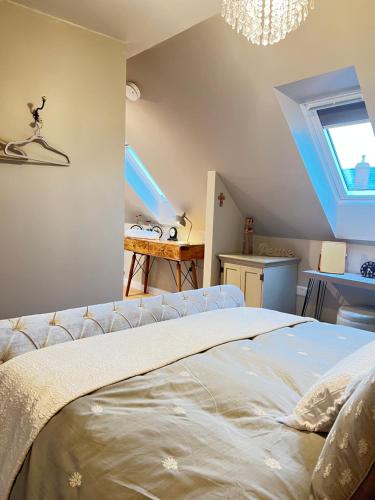 een slaapkamer met een bed en een kroonluchter bij Entire Loft Space in quiet village near Roman City of Lincoln in Lincoln