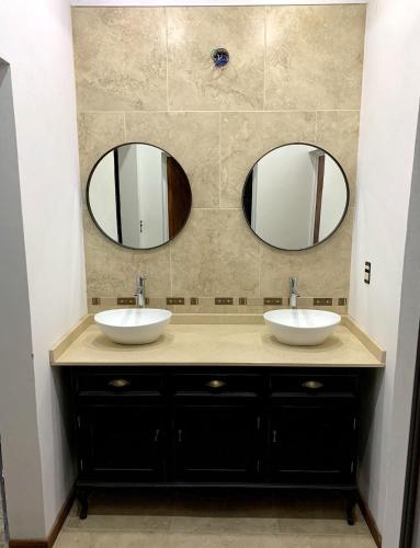 a bathroom with two sinks and two mirrors at Ruka Baradero in Baradero