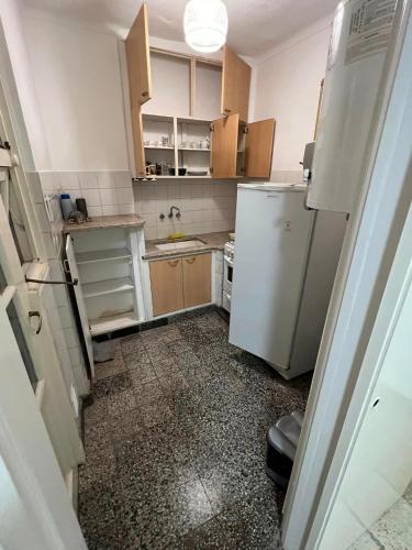 una pequeña cocina con nevera blanca y armarios en Departamento en el centro de Mar Del Plata en Mar del Plata
