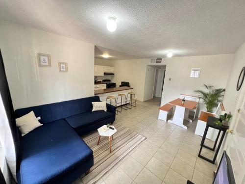 a living room with a blue couch and a kitchen at Departamento, recién remodelado a 3 min USA. 2 in Ciudad Juárez