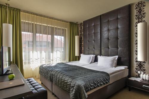 a bedroom with a large bed and a large window at Ores Boutique Hotel in Bansko