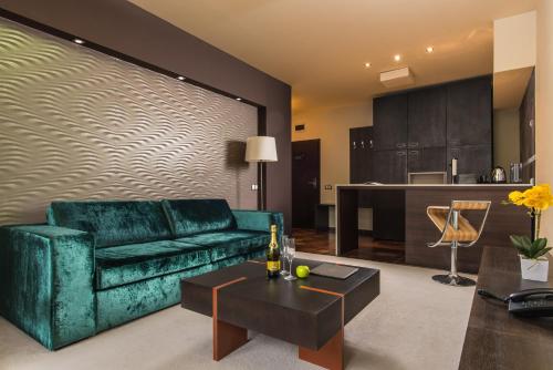 a living room with a green couch and a kitchen at Ores Boutique Hotel in Bansko