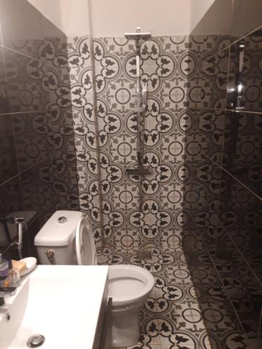 La salle de bains est pourvue de toilettes et de carrelage noir et blanc. dans l'établissement Résidence Edelweiss, à Dakar