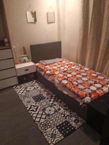 - une petite chambre avec un lit et un tapis dans l'établissement Résidence Edelweiss, à Dakar