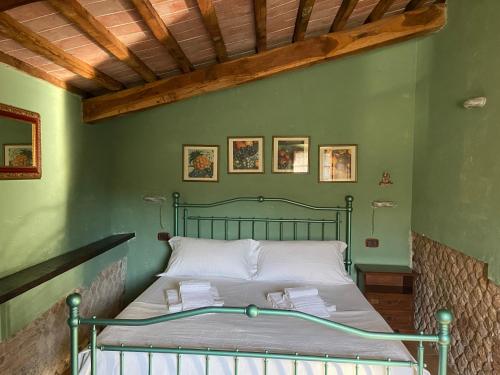 uma cama num quarto com paredes verdes em Agriturismo Relais Villa Passerini em Grosseto