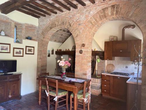 uma cozinha com uma mesa com um vaso de flores em Agriturismo Relais Villa Passerini em Grosseto