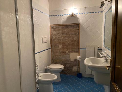 a bathroom with a white toilet and a sink at Agriturismo Relais Villa Passerini in Grosseto