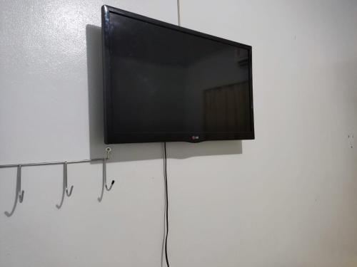 uma televisão de ecrã plano pendurada numa parede branca em HOTEL REAL em Marechal Cândido Rondon