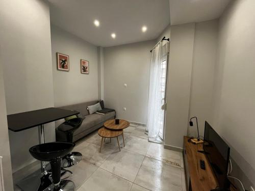 uma sala de estar com um sofá e uma mesa em Modern flat Ag. Dimitriou em Tessalônica