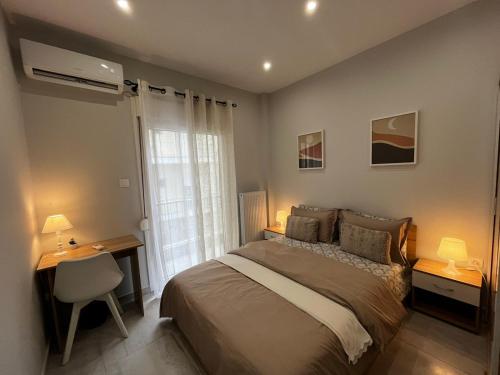 um quarto com uma cama, uma secretária e uma janela em Modern flat Ag. Dimitriou em Tessalônica