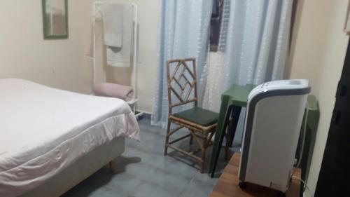 - une chambre avec un lit, une chaise et une table dans l'établissement Hospedagem Lirio, à Bragança Paulista