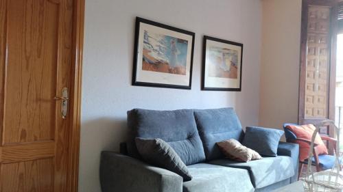 sala de estar con sofá azul y 2 cuadros en Economic private room in center of Granada, en Granada