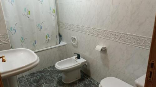 Baño blanco con aseo y lavamanos en Economic private room in center of Granada, en Granada