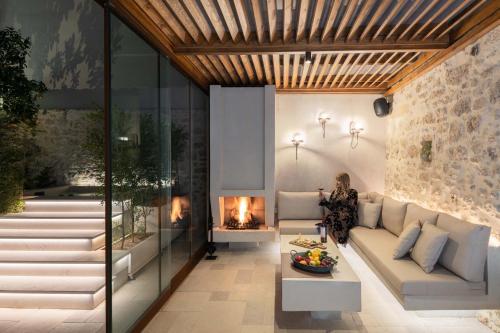 a woman standing in a living room with a fireplace at Inotropes Boutique Suites - Adults Only in Archanes