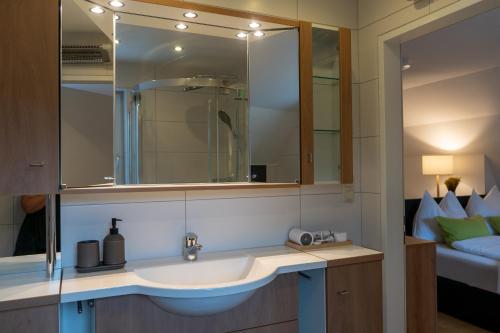 a bathroom with a sink and a mirror and a bed at s`Hauserl 311 in Altaussee