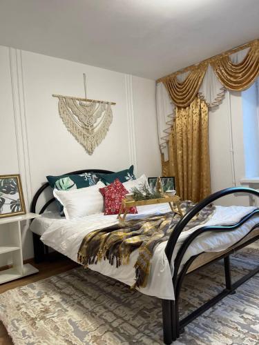 um quarto com uma cama grande com almofadas em Дизайнерская трехкомнатная квартира em Karaganda