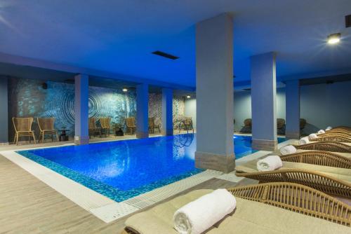 a pool in a hotel with lounge chairs at Ores Boutique Hotel in Bansko