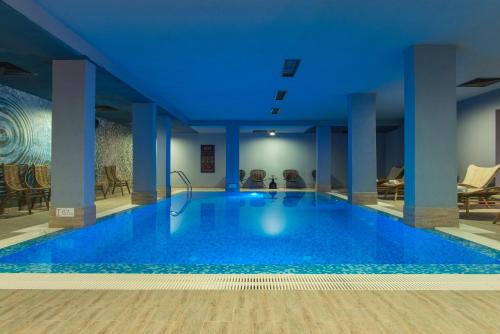 a large blue swimming pool in a building at Ores Boutique Hotel in Bansko