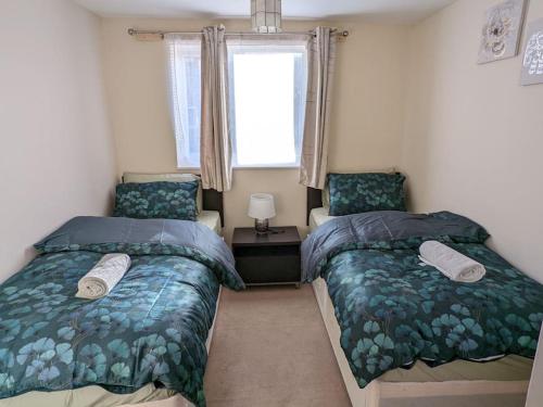 a bedroom with two beds and a window at LTK Basildon in Nevendon