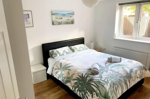 a bedroom with a bed with a tropical bedspread at Modern & Stylish 2 Bedroom Apartment! - Ground Floor - FREE Parking for 2 Cars - Netflix - Disney Plus - Sky Sports - Gigabit Internet - Newly decorated - Sleeps up to 5! - Close to Bournemouth Train Station in Bournemouth