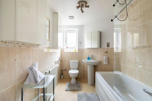 a bathroom with a toilet and a sink and a tub at Modern & Stylish 2 Bedroom Apartment! - Ground Floor - FREE Parking for 2 Cars - Netflix - Disney Plus - Sky Sports - Gigabit Internet - Newly decorated - Sleeps up to 5! - Close to Bournemouth Train Station in Bournemouth