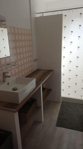 La salle de bains est pourvue d'un lavabo blanc et de parquet. dans l'établissement 400m de la plage Maison 3 chambres avec jardin, à Saint-Georges-de-Didonne