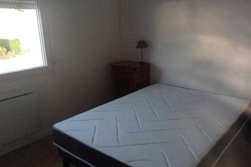 une petite chambre avec un lit et une fenêtre dans l'établissement 400m de la plage Maison 3 chambres avec jardin, à Saint-Georges-de-Didonne