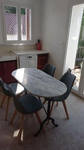 une cuisine avec une table et des chaises dans une cuisine dans l'établissement 400m de la plage Maison 3 chambres avec jardin, à Saint-Georges-de-Didonne