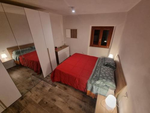 - une petite chambre avec un lit rouge et un miroir dans l'établissement La casetta di Maty&Fra, à Pistoia