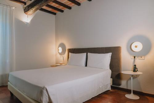 a bedroom with a white bed and two lamps at Locanda Del Feudo Suite & Restaurant in Castelvetro di Modena