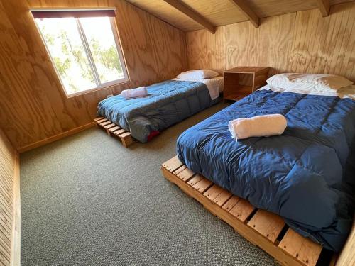 a bedroom with two beds and a window at Hospedaje Hamiltons Place in La Ensenada