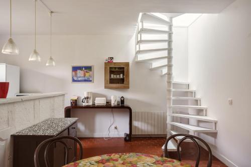 a kitchen with a staircase and a table and chairs at Le Moulin de Dannemarie in Dannemarie