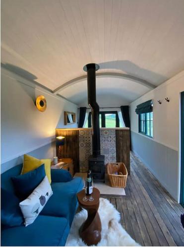 a living room with a blue couch and a stove at Pilgrims Nap in Rainham