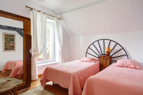 a bedroom with two beds and a mirror at Le Moulin de Dannemarie in Dannemarie