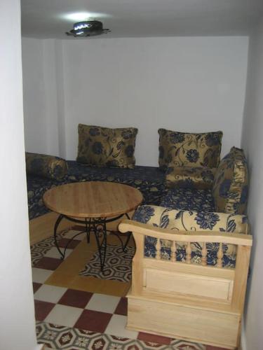 a living room with a table and a couch at Appartement dans la médina in Asilah