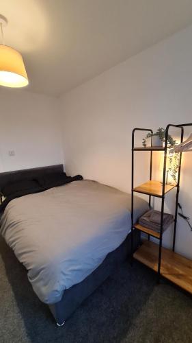 a small bedroom with a bed and a shelf at The "Cleveland" Apartment in Redcar