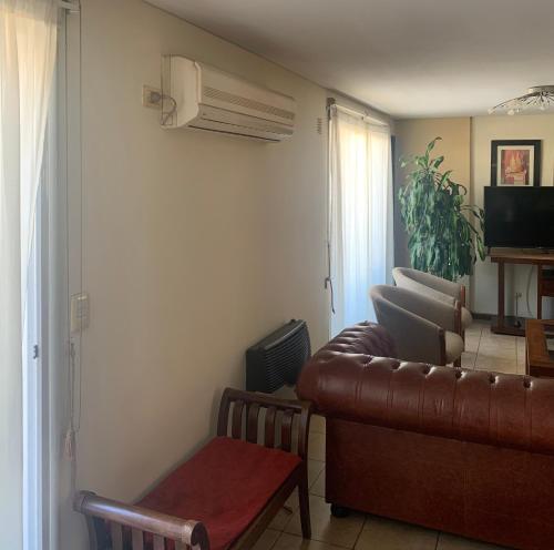 a living room with a leather couch and a television at HERMOSO DÚPLEX DE CATEGORÍA COMPLETAMENTE EQUIPADO in Cordoba