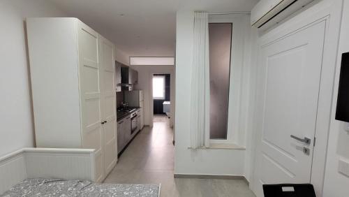 a kitchen with white cabinets and a hallway at Maison Ginevra in Pompei